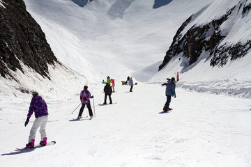 Skiers and snowboarders going down the slope.