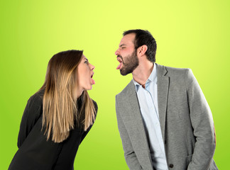 Couple sticking out her tongue over green background