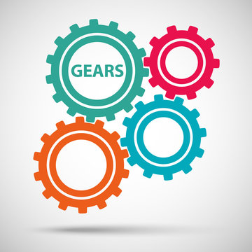 Multicolored toothed gears (cogs) is meshed on gray background