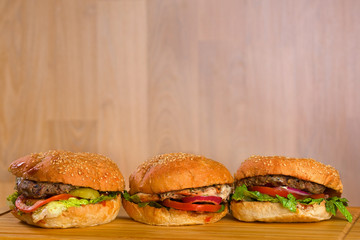 Three tasty burger with melted cheese and thick succulent ground
