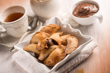 tea cup and cookie stuffed with chocolate cream, selective focus