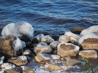 Fototapeta na wymiar stones in the ice on the lake