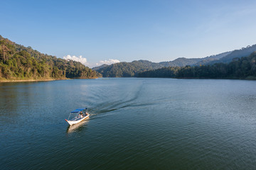 Fototapeta na wymiar Speed boat cruising through a lake in a rainforest