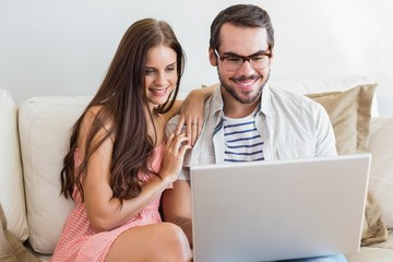 Hipster couple using laptop on couch