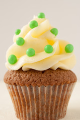 Green sweets on buttercream with chocolate cupcake