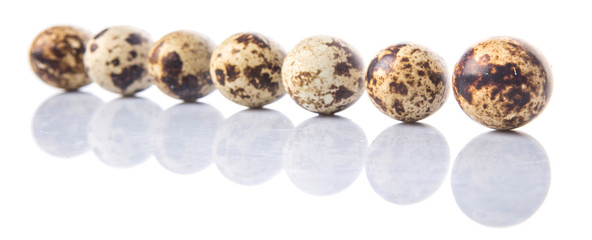 Quail eggs over white background