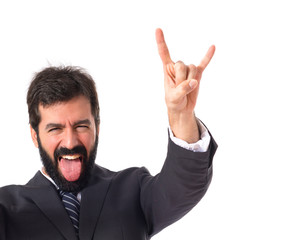Businessman making horn gesture over white background