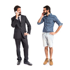 Twins talking to mobile over white background