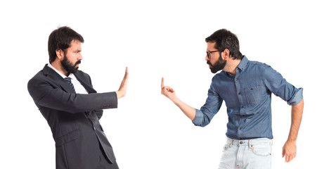 Hipster man making horn gesture at his brother