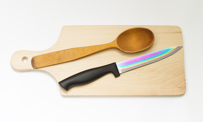 One wooden spoon and knife on the board