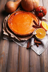 Homemade pumpkin pie on napkin, on wooden background