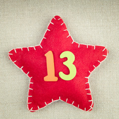 Red star with wooden number 13 on vintage fabric background
