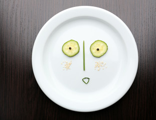 Vegetable face on plate on wooden table