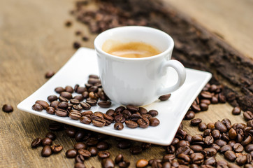 A cup of espresso and coffee beans on an old wooden table :)