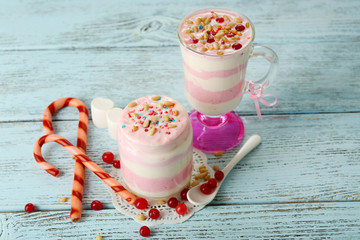 Cranberry milk dessert in glass and glass jar,