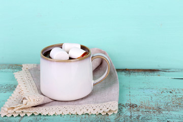 Cup of tasty hot cocoa, on wooden table, on color background