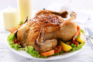 Delicious baked chicken on plate on table on light background
