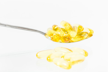 Omega 3 fish oil capsules on spoon