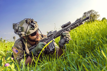 American Soldier aiming his rifle on blue sky background