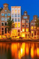 Naklejka premium Nocny widok na kanał Amsterdamu z holenderskimi domami