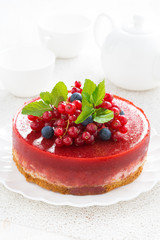 cheesecake with berry jelly on a plate, vertical