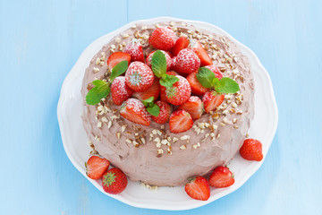 chocolate cake with fresh strawberries on a blue background