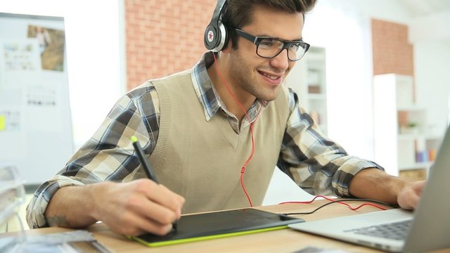 Young man in office using graphic tablet 