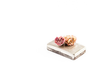 Old rusty tobacco box with two roses on top