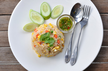 Pork fired rice in white plate on wooden table, TOP VIEW.