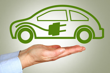 Hand holding symbolic electric car