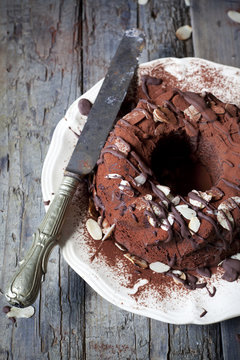 ring-shaped cake covered with cocoa powder and almond slices