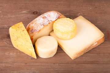 Various types of cheese on a wooden background
