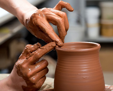 hands of a potter, creating an earthen jar