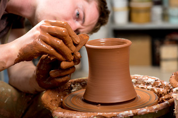 hands of a potter, creating an earthen jar
