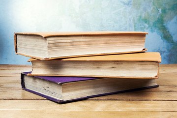 Three old books on wooden table