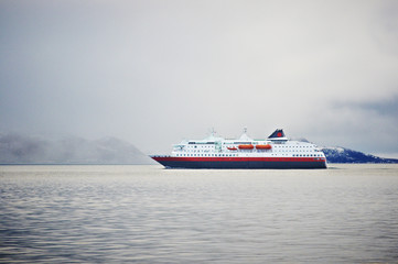 Norwegian ferry cruising in fiord in winter quiet landscape