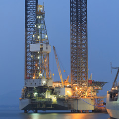 Jack up oil drilling rig in the shipyard in the evening