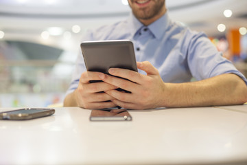 Young Businessman seating on table in restoran and use mobile de