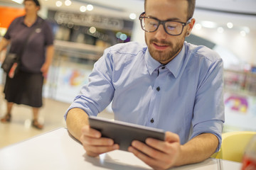 Young Businessman seating on table in restoran and use mobile de