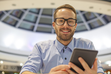 Young Businessman seating on table in restoran and use mobile de