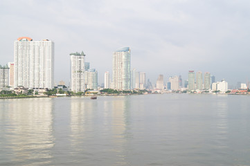 Obraz premium budynki, rzeka, drzewa i łódź w Bangkoku w Tajlandii