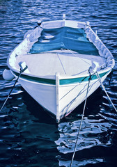 A small wooden boat anchored in the bay