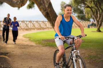 Obraz premium Male riding his bicycle while others run