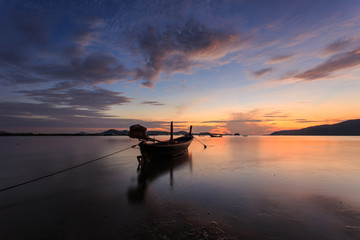 Silhouettes of longtail boat and sunrise in Phuket, Thailand