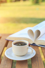 Coffee cup and book on the table in the morning
