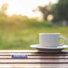 Monday written in letter beads and a coffee cup on table