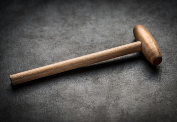 Wooden hammer on dark background. Selective focus.