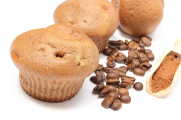 Obraz na płótnie Canvas Fresh baked muffins, coffee grains and powdery cinnamon