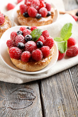 Sweet cakes with berries on table close-up