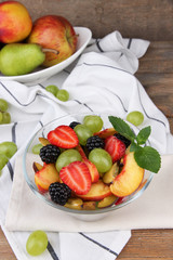 fresh tasty fruit salad on wooden table
